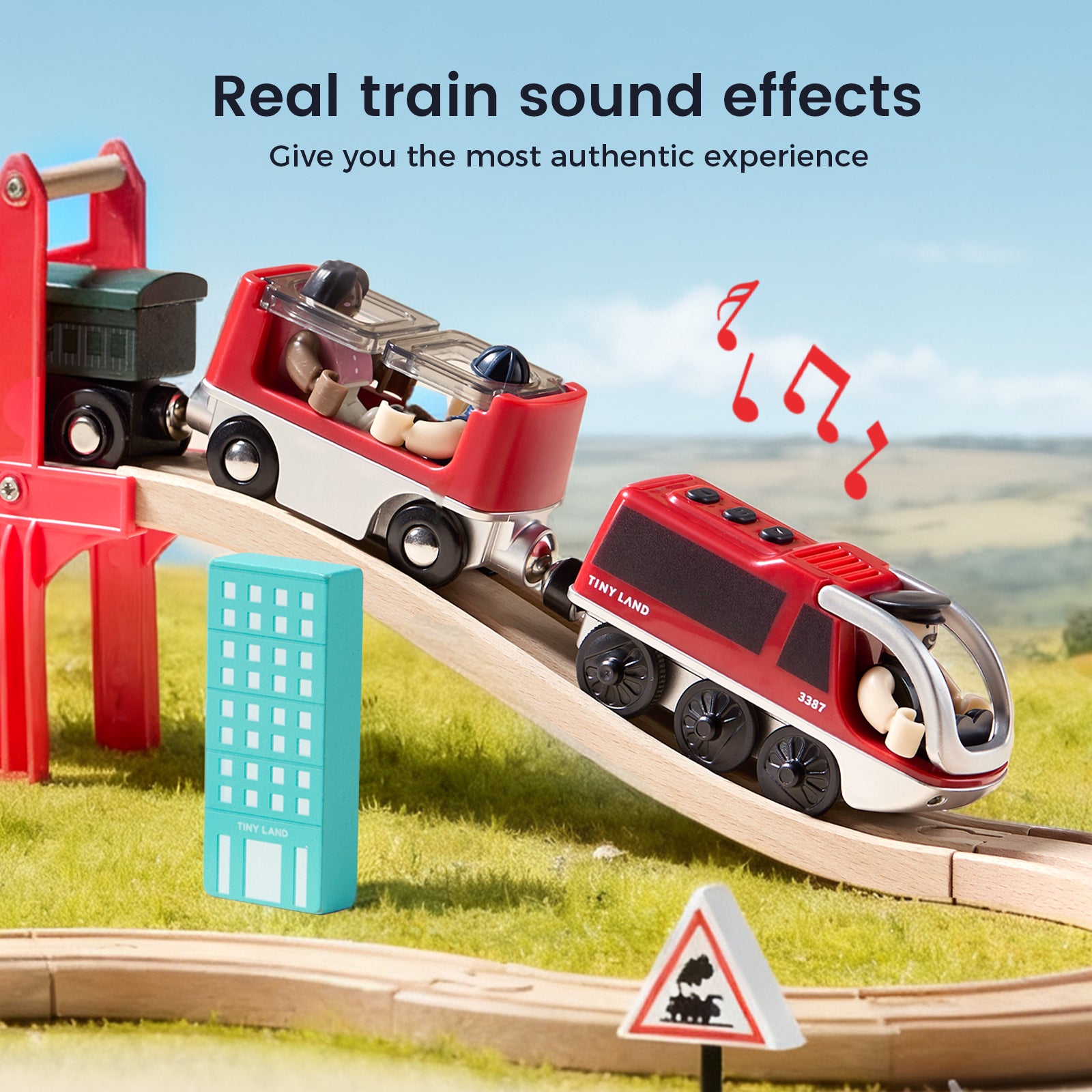 The Tiny Land® Dual-Color Electric Toy Train features two red cars on a wooden track in grass, with music notes showing real train sound effects. Interactive play is added by a blue block and traffic sign. Brand: Tiny Land.|Red