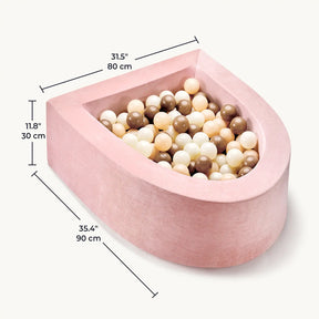 The Tiny Land® PlayNest Ball Pit by Tiny Land features pink velvet, a semi-circular foam design (35.4" x 31.5" x 11.8"), and comes with 200 beige, cream, white, and brown ocean balls—perfect for a cozy toddler play space.|Pink
