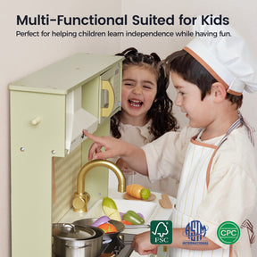 Two young children play with the Tiny Land® PopJoy Play Kitchen in Pink and Green, pretending to cook using plastic food and utensils. The text above highlights how this play kitchen from Tiny Land encourages learning independence. Certification logos appear at the bottom.|Sage