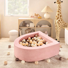 A cozy children's playroom featuring the Tiny Land® Pink PlayNest Ball Pit by Tiny Land INC (Ocean Balls not included), a large giraffe plush toy, pastel decor, a bookshelf, and soft, neutral-toned furniture.|pink