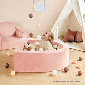 A young child sits happily in the Tiny Land® PlayNest Ball Pit – Ocean Balls Not Included, surrounded by beige, white, and brown balls. The child laughs as balls float nearby; a pink chair and white play tent are visible in the background.|pink