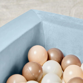 A close-up of the Tiny Land® Blue PlayNest Ball Pit with 200 ocean balls by Tiny Land INC, filled with beige, brown, and cream balls. The softly blurred background highlights the cozy play nest and colorful balls inside.|blue