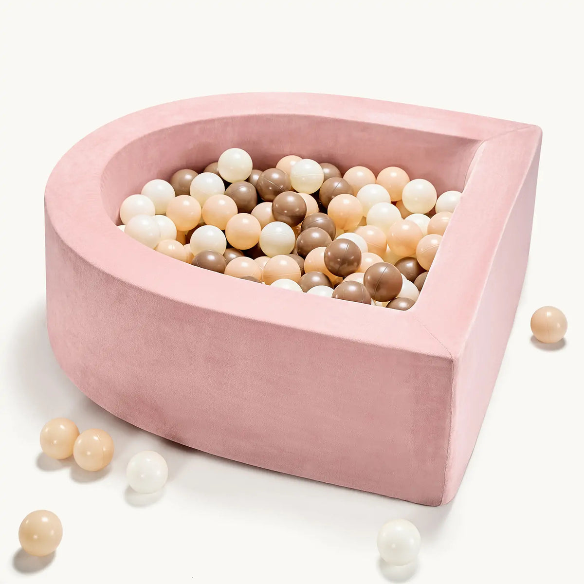 The Tiny Land® PlayNest Ball Pit with 200 Ocean Balls by Tiny Land INC features a pink, pear-shaped foam nest, filled with white, beige, cream, and brown balls. A few ocean balls are scattered outside on a light background. Ideal as a cozy toddler ball pit.|Pink