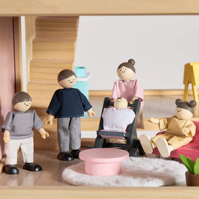 The Tiny Land® Sweetwood Love Dollhouse by Tiny Land INC features a cozy, modern living room with pastel decor and comes with five wooden peg dolls—two adults, two children, and a baby in a stroller—for imaginative play.