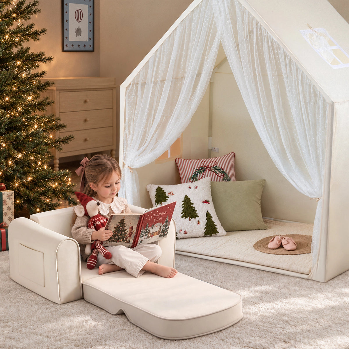 A young girl sits on a Tiny Land Cozy Nook Bundle – Kids Tent with Star Lights & GentleSnug Chair reading a book next to a cozy play nook with sheer curtains.|Mesh