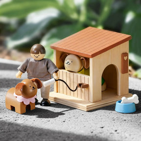 The Test Early Bird Eggs-Tiny Land® Happy Urban Paws set includes a figure with a leashed brown dog in a pink collar, a mini pet house with another dog inside, and a blue bowl with a bone, all against blurred green foliage.