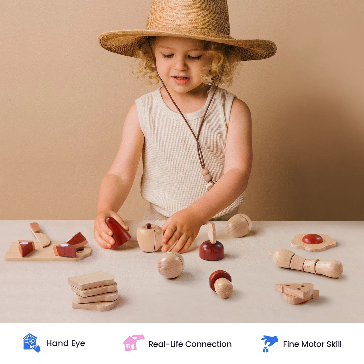A young child wearing a straw hat plays at a table with the Tiny Land® Play Kitchen Accessories – Play Food for Play Kitchen: Wooden Cut and Play Food Toys by Tiny Land Play Food. Icons below highlight benefits such as hand-eye coordination, real-life connection, and fine motor skill development.
