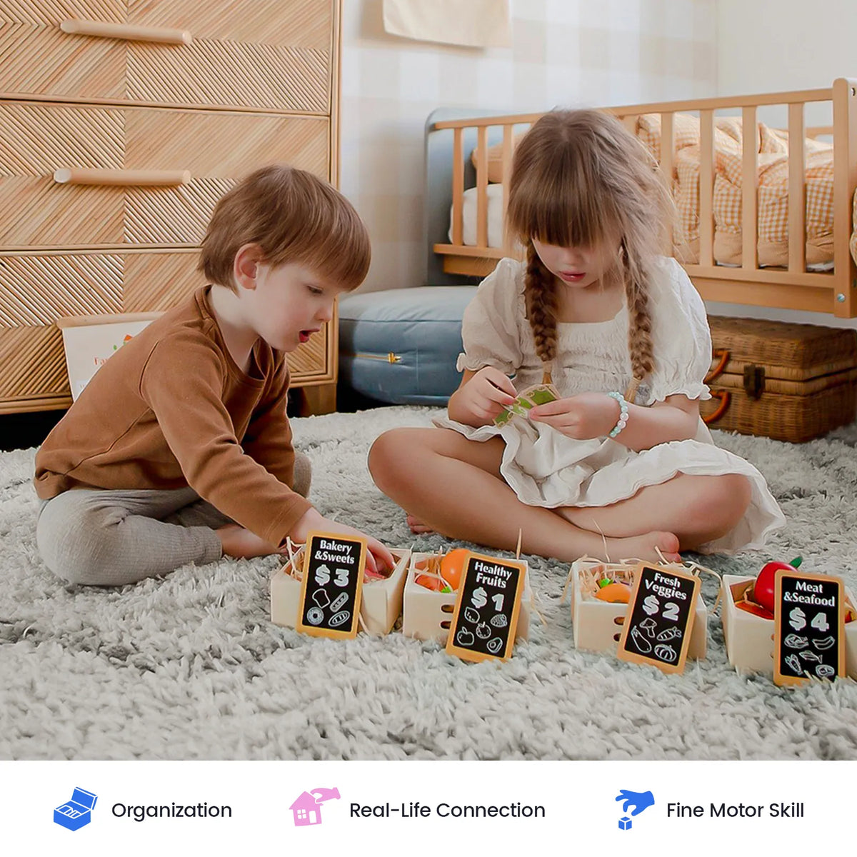 Two young children sit on a soft rug, sorting pieces from the Tiny Land® Wooden Food for Play Kitchen & Wooden Rack set into labeled baskets. The cozy room features a wooden dresser and bed in the background—creating an ideal space for pretend play. Three icons below highlight organization, real-life connection, and fine motor skills, showcasing the benefits of this educational toy from Tiny Land Play Food.