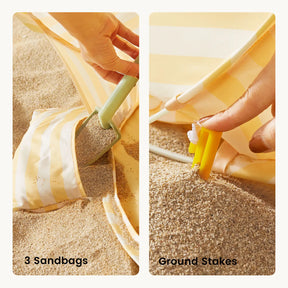 A hand fills a sandbag for the Tiny Land® One-Stop Beach Toy & Tent Set – Pastel Yellow Stripes, while another secures a yellow ground stake beside the striped fabric. Text reads “3 Sandbags” and “Ground Stakes.”.