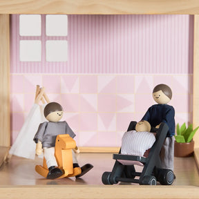 Three Tiny Land® Sweetwood Love Dollhouse & Wooden Dollhouse Dolls from Tiny Land INC enjoy imaginative play in a cozy room with pink patterned walls, a teepee, and a small plant—one rocks on a horse while another pushes the baby in a stroller.