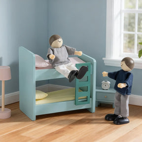 Two Tiny Land® Wooden Dollhouse Dolls by Tiny Land INC play in a 1:12 cozy bedroom with a blue bunk bed, lamp, side table, alarm clock, and window—one doll sits on the top bunk while the other stands below.