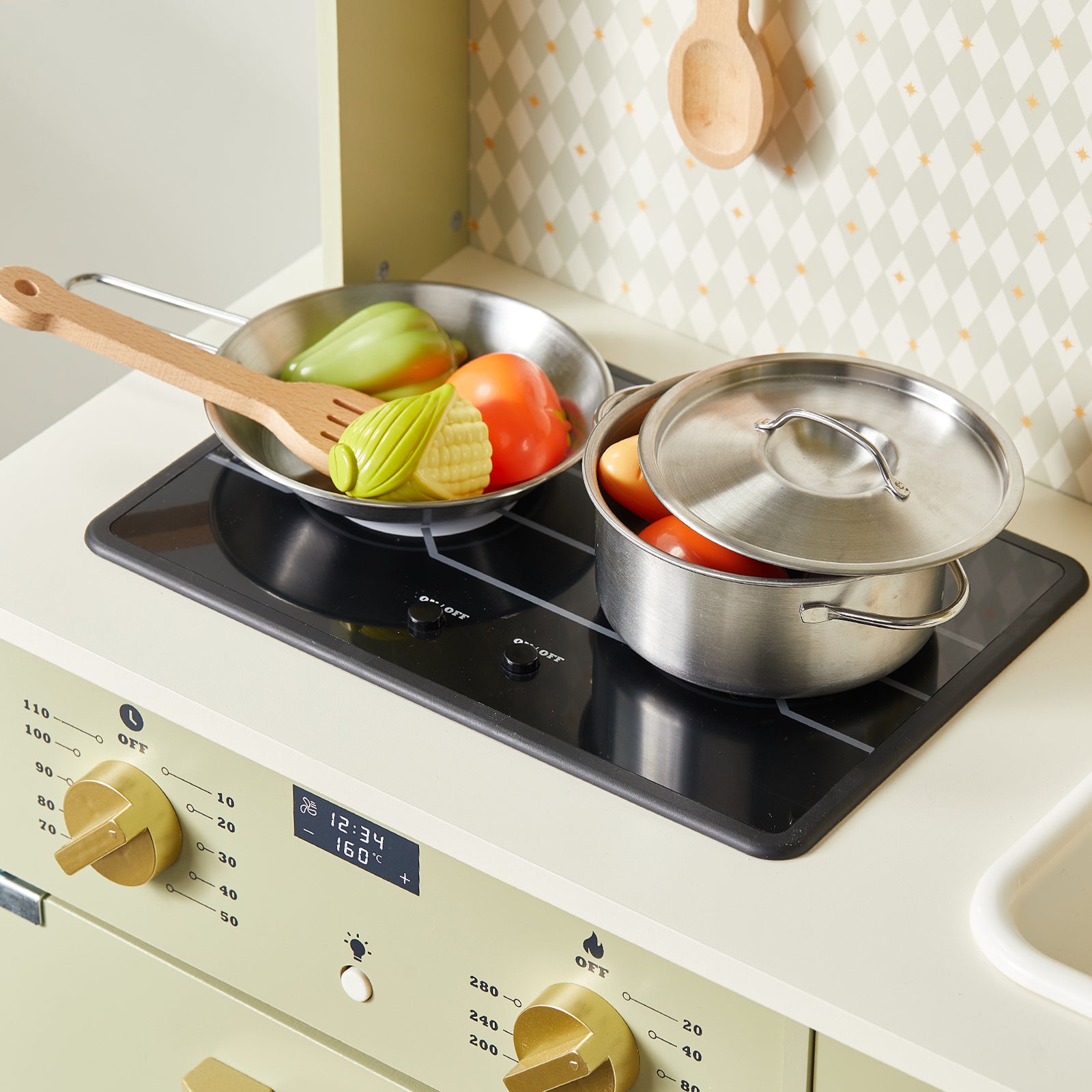 Two metal pots from the Tiny Land® PopJoy Play Kitchen (Pink / Green) sit on the stovetop; one with a lid, both filled with toy vegetables. A wooden spoon rests in the open pan. This charming setup by Tiny Land is perfect for inspiring pretend play adventures.|Sage