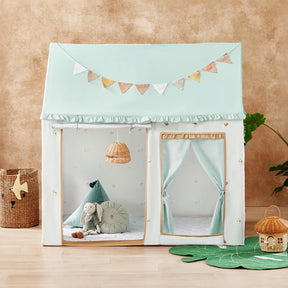 The Tiny Land® Sweet Woodland Kids Play Tent by Tiny Land INC is a pastel blue, house-shaped play tent with curtains and a bunting banner, shown on a wooden floor with plush toys and decor against a beige wall.