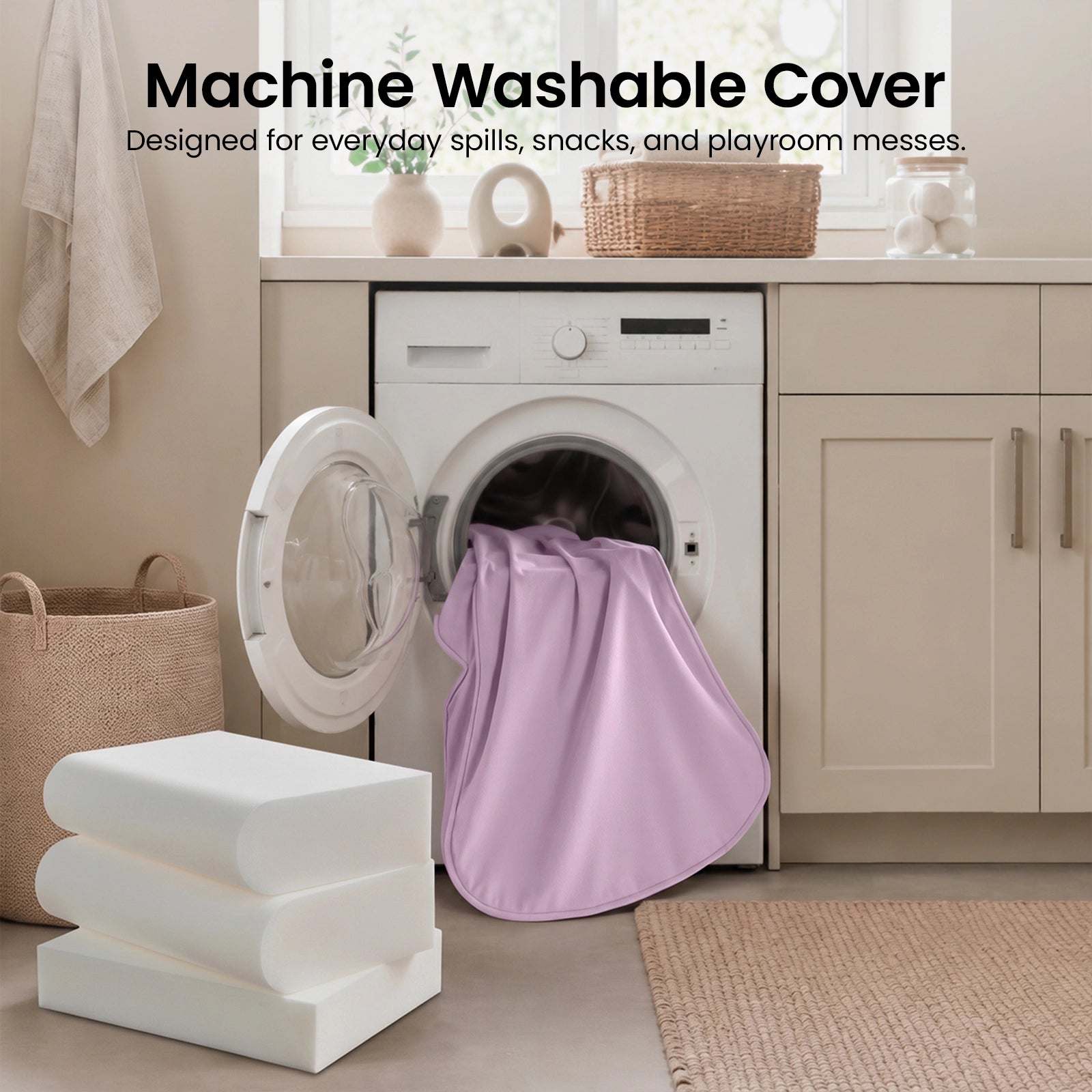 A pink fabric cover from the Tiny Land® GentleSnug Kids Sofa Chair is being placed into a front-loading washing machine in a modern laundry room. Three white foam cushions and a woven basket sit nearby. Text reads: Machine Washable Cover.|Light Purple