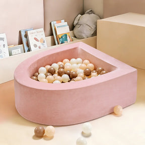 The Tiny Land® Pink PlayNest Ball Pit by Tiny Land INC, a soft, heart-shaped addition to any playroom, invites sensory fun among books and toys.|pink