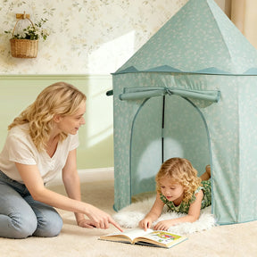 A woman kneels beside a young girl lying on a rug inside the Tiny Land® Tiny Sprout Castle Tent, reading a book together and creating a cozy reading nook.