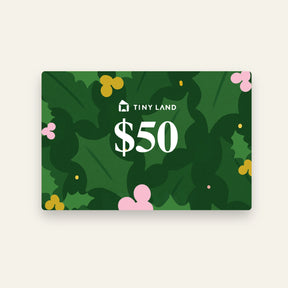A $50 Tiny Land® Gift Card by Giftnote, featuring a festive green holly leaf background with pink and yellow berries.