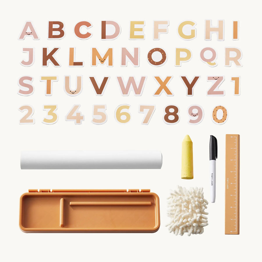 The Tiny Land® Double-Sided Magnetic Tabletop Easel by Tiny Land includes pastel alphabet letters, numbers, a yellow crayon, black marker, wooden ruler, cotton swabs, an orange case, and a white cylindrical object—all neatly arranged on a light background—making it perfect for inspiring creativity at any art station or magnetic whiteboard.|Oatmeal