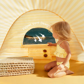 A young child sits inside the Tiny Land® One-Stop Beach Toy & Tent Set – Pastel Yellow Stripes, peering out a zippered vent toward the ocean. Arrows highlight the unique vent design. Wicker mats are stacked nearby.