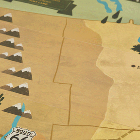 A close-up of the Tiny Land® 1920 Railway Adventure Train Table by Tiny Land INC shows a stylized map in brown, green, and yellow with mountains, rivers, Route 66, and a vintage city railway toy on a section labeled TINY LAND.
