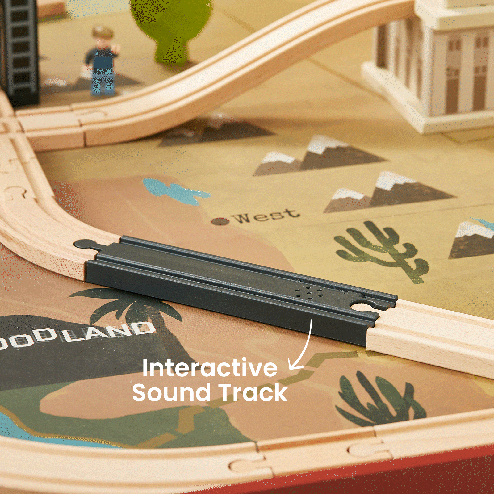 The Tiny Land® 1920 Railway Adventure Train Table by Tiny Land INC includes a wooden 1920s train set on a desert-themed mat with an interactive black sound track, plus toy trees, figures, and buildings for a city playset experience.