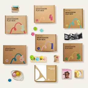 A flat lay of several Tiny Land® Montessori Complete Baby Sets (0-24 months) from Tiny Land, each numbered 1 to 6 in colorful print, with toys, an "Emotions" book, and assorted wooden and plastic sensory play items arranged neatly.