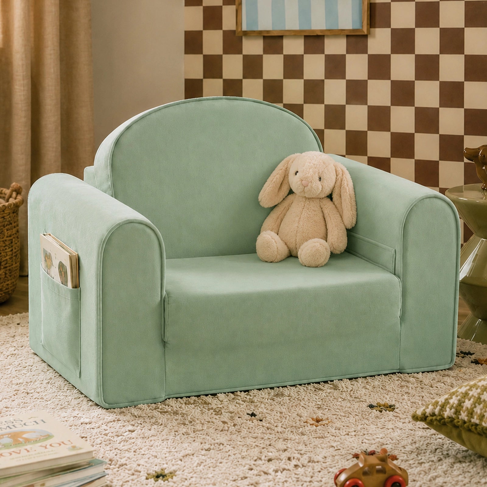 The Tiny Land® GentleSnug Kids Sofa Chair in light green, featuring a side pocket holding a soft beige bunny, sits on a carpeted floor in a cozy room with books and toys nearby.