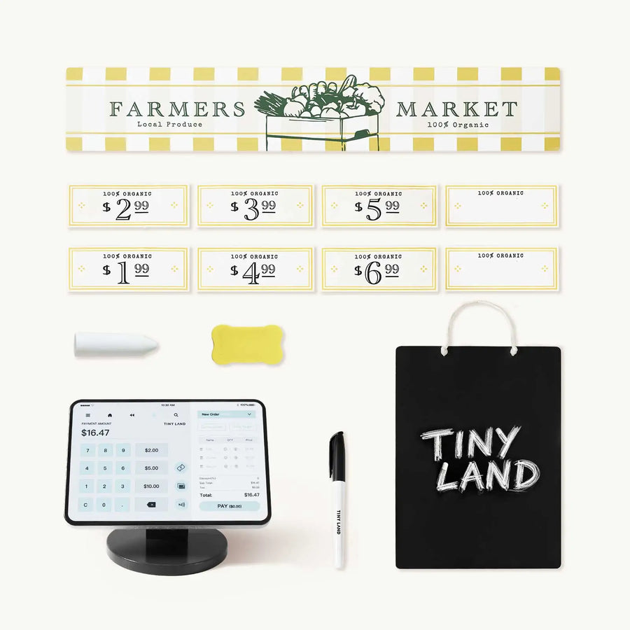 The Tiny Land® Farm-to-Table Gift Set by Tiny Land includes a “Farmers Market” sign, produce tags, a toy checkout register with lights and sounds, marker, eraser, chalkboard bag labeled “Tiny Land,” and a white card for endless pretend play.