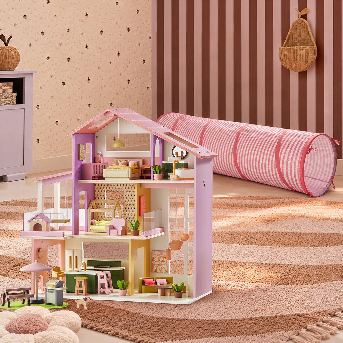 A Tiny Land® Sweetwood Adventure Dollhouse & Play Tunnel Set featuring a multi-story dollhouse with miniature furniture and a pink-and-white striped play tunnel on a rug for imaginative play.
