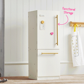 A white Tiny Land® BistroSwitch Kitchen & Fridge Set with gold handles stands against a white wall. An apron hangs nearby, and pink text with an arrow points to the fridge, reading Functional Storage—making this Tiny Land set a stylish addition to any kid’s play kitchen or pretend play area.