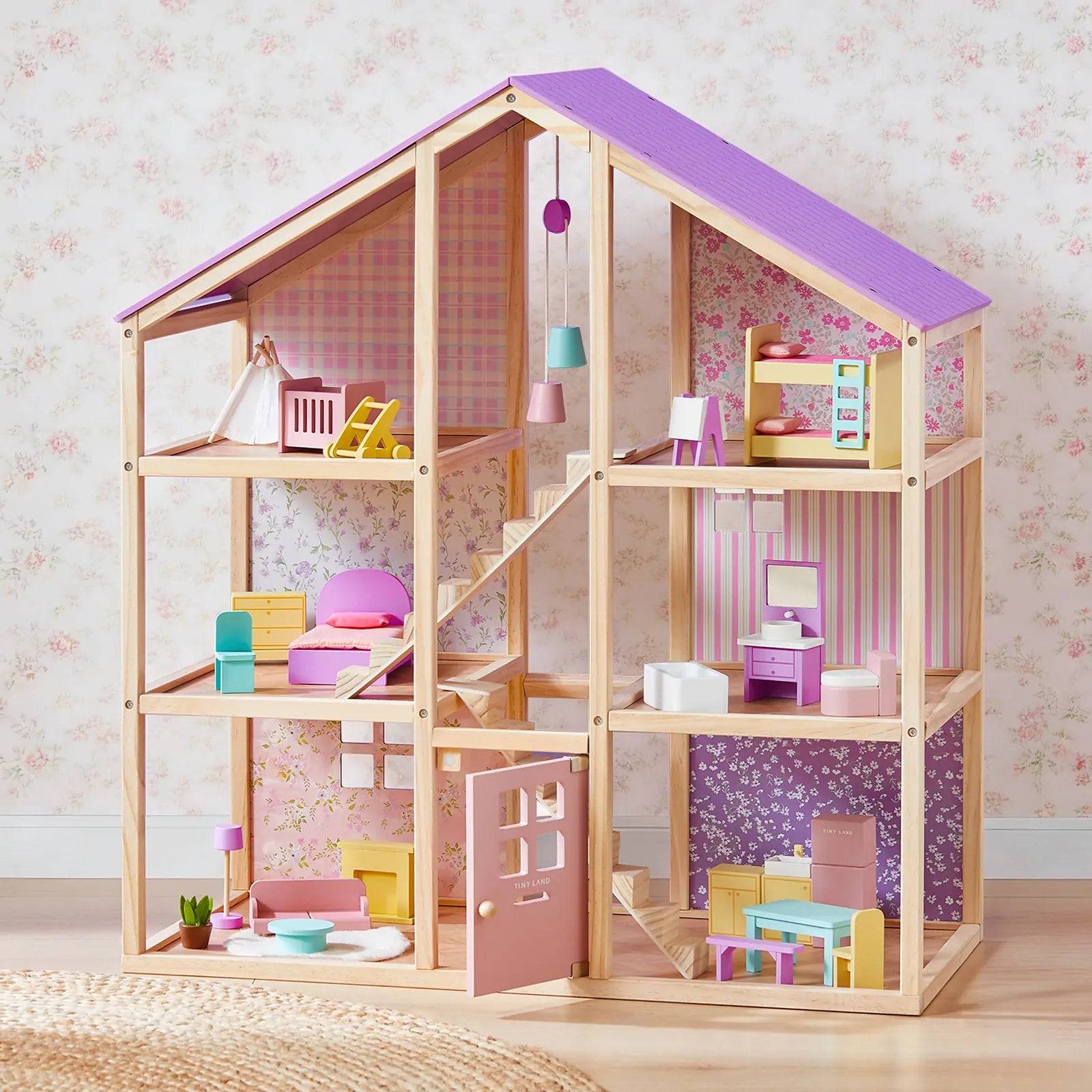 The Tiny Land® Sweetwood Unicorn Dollhouse by Tiny Land features a purple roof, six rooms, colorful miniature furniture, and poseable dolls set against floral wallpaper with a woven rug on the floor.