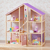 The Tiny Land® Sweetwood Unicorn Dollhouse by Tiny Land features a purple roof, six rooms, colorful miniature furniture, and poseable dolls set against floral wallpaper with a woven rug on the floor.