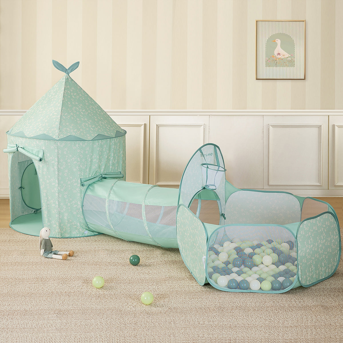 The Tiny Land® Adventure 3-in-1 Play Tunnel & Ocean Ball Set - Green by Tiny Land, featuring a play tent, tunnel, and ball pit with colorful balls, is arranged on a beige carpet with a plush bunny toy and scattered balls in the softly decorated room.