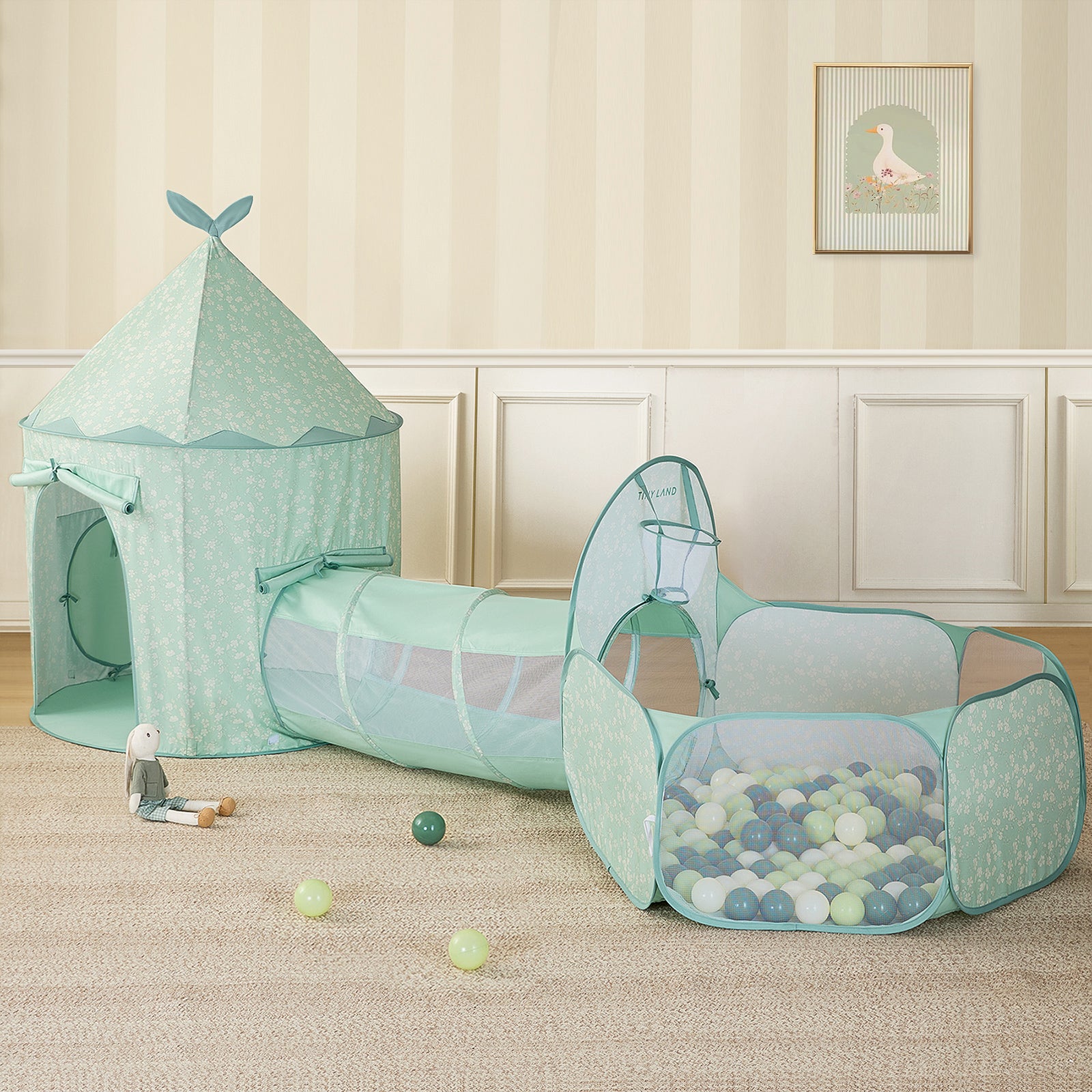 The Tiny Land® Adventure 3-in-1 Play Tunnel & Ocean Ball Set - Green by Tiny Land, featuring a play tent, tunnel, and ball pit with colorful balls, is arranged on a beige carpet with a plush bunny toy and scattered balls in the softly decorated room.