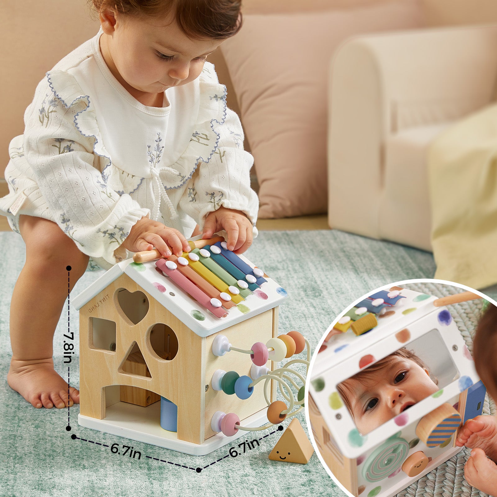 A baby plays on a carpet with the Tiny Land® Cottage Activity Cube - Morandi, featuring a xylophone, shape sorter, bead maze, and mirror. An inset shows the baby’s reflection in the mirror; toy measurements are also displayed. Brand: Tiny Land.
