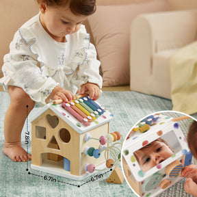 A baby plays on a carpet with the Tiny Land® Cottage Activity Cube - Morandi, featuring a xylophone, shape sorter, bead maze, and mirror. An inset shows the baby’s reflection in the mirror; toy measurements are also displayed. Brand: Tiny Land.