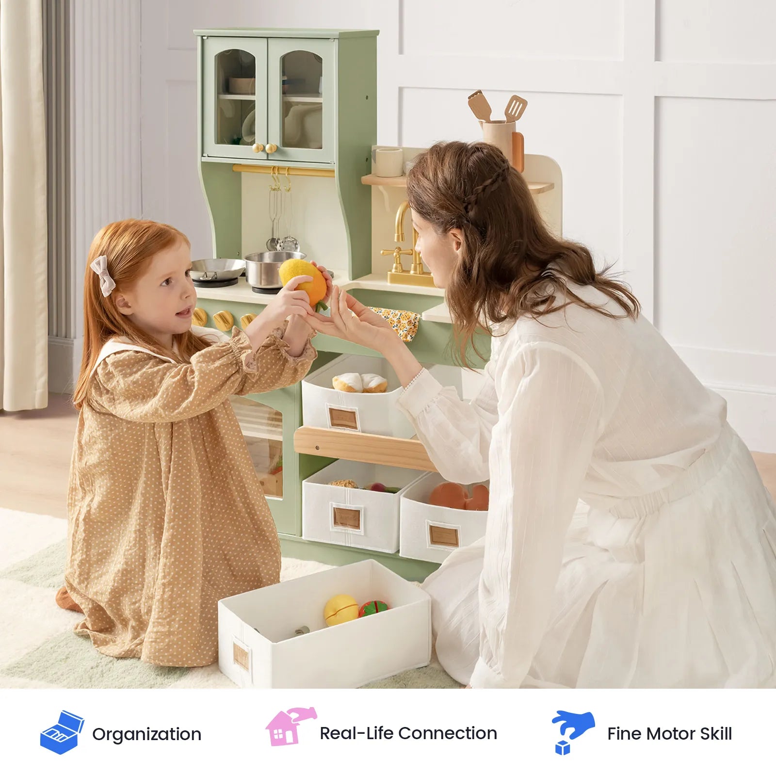 A woman kneels beside a young girl as they play with toy food in the Tiny Land® Wooden Play Kitchen with Storage for Creative Toddlers, discovering its engaging features and enjoying pretend cookware together. Three icons below highlight: Organization, Real-Life Connection, and Fine Motor Skill.|sage