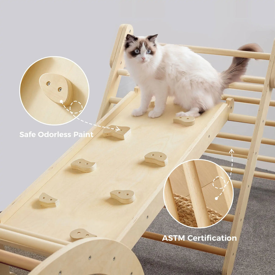 A fluffy white and gray cat sits on the Tiny Land® 7-in-1 Montessori Climbing Set with Play Pad by Tiny Land, which has small handles, “Safe Odorless Paint,” “ASTM Certification,” and rests on a carpeted indoor floor.|natural wood color