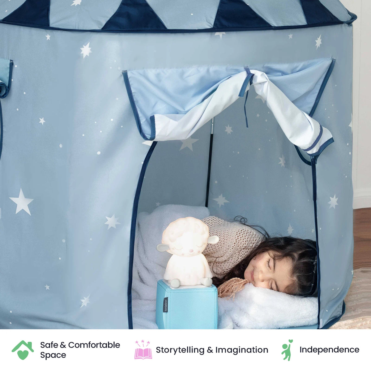 A young girl sleeps inside the Tiny Land® Kids Tent – Indoor Tent for Toddlers, surrounded by a soft toy lamp and a cozy pillow. Icons below highlight safe space, storytelling and imagination, and independence—showcasing how this charming play tent from Tiny Land creates the perfect indoor playhouse for little dreamers.|Blue