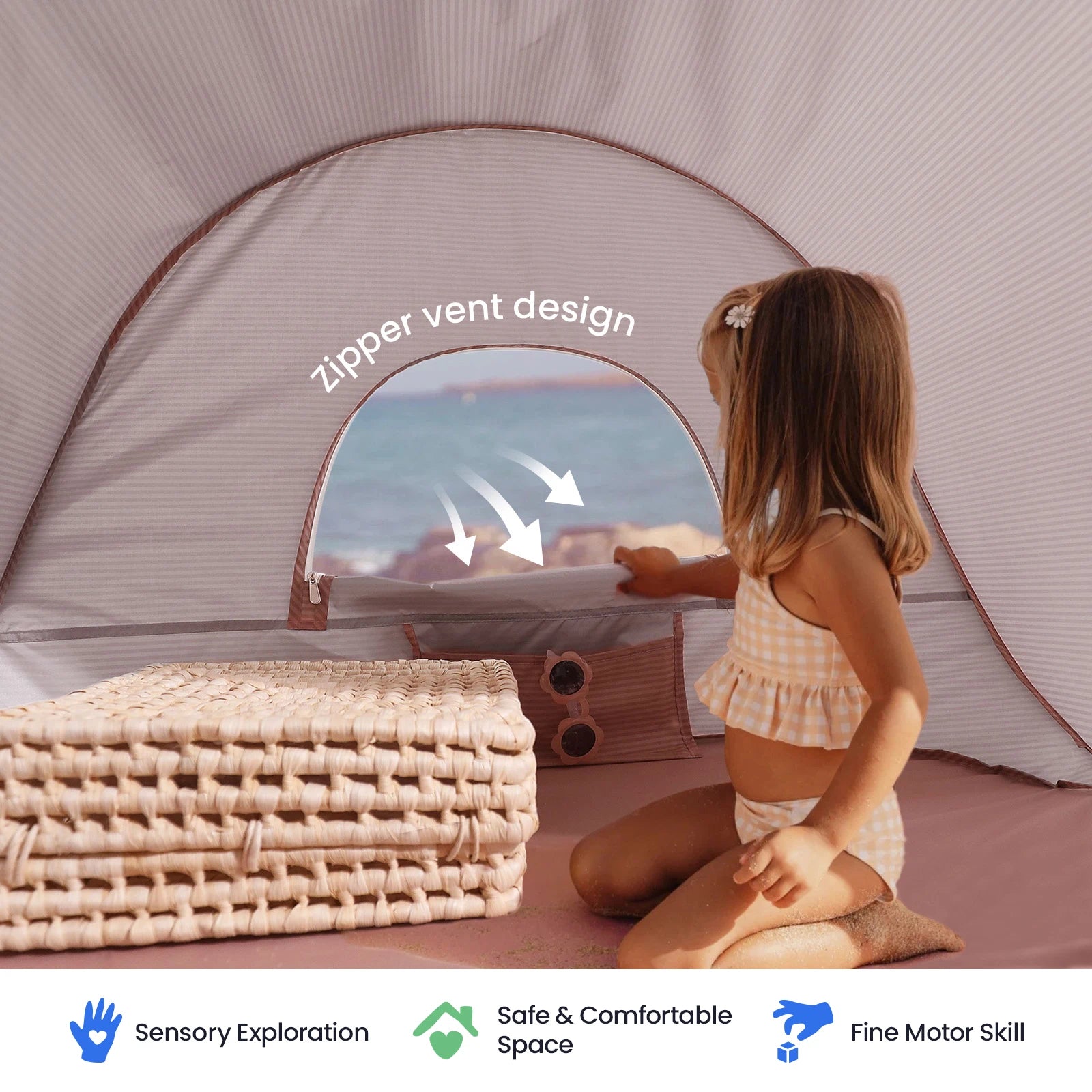 A young girl in a striped swimsuit sits inside the Tiny Land® One-Stop Beach Toy & Tent Set by the shore, with an open zipper vent for airflow. Folded mats and icons highlight sensory exploration, UV protection, safety, and support for fine motor skills.|Blush Pink