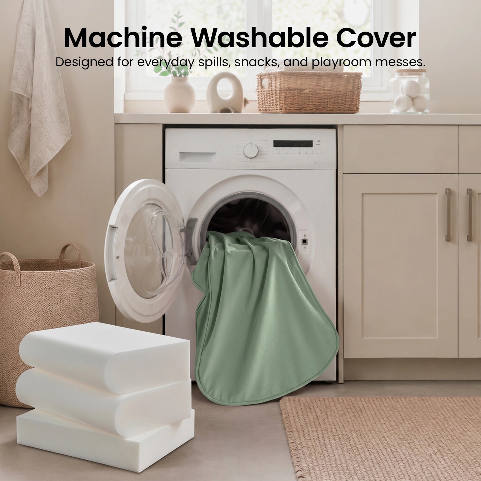 A green fabric cover from the Tiny Land® GentleSnug Kids Sofa Chair is halfway inside a front-loading washing machine in a laundry room, with folded white foam cushions and baskets nearby. Text above reads: Machine Washable Cover.|Light Green