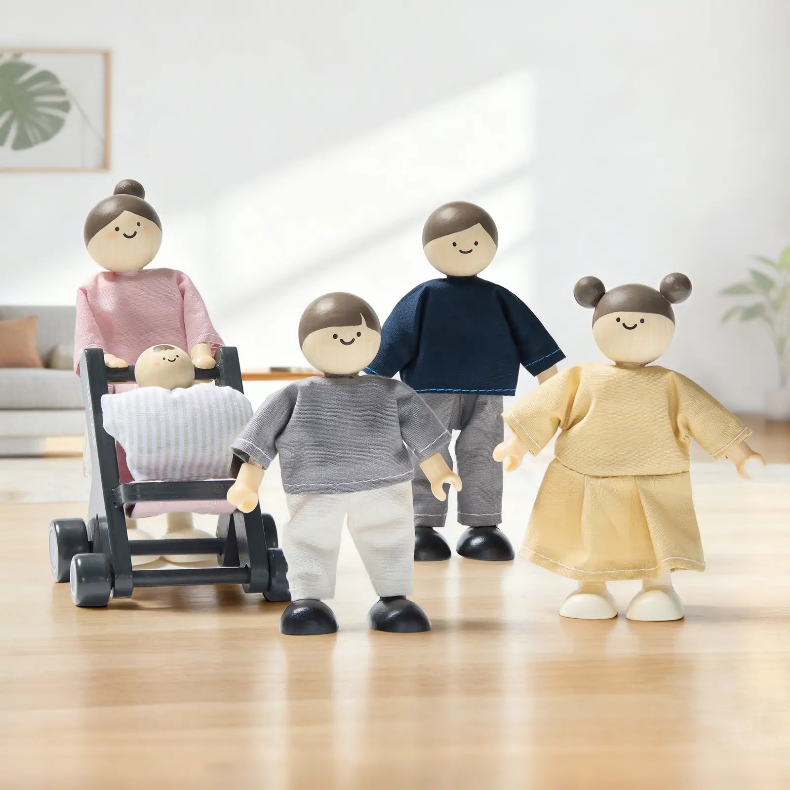 The Tiny Land® Wooden Dollhouse Dolls from Tiny Land include five natural wood figures with simple faces. One doll pushes a stroller with a baby inside. The poseable family wears pastel outfits, perfect for modern dollhouse playrooms.