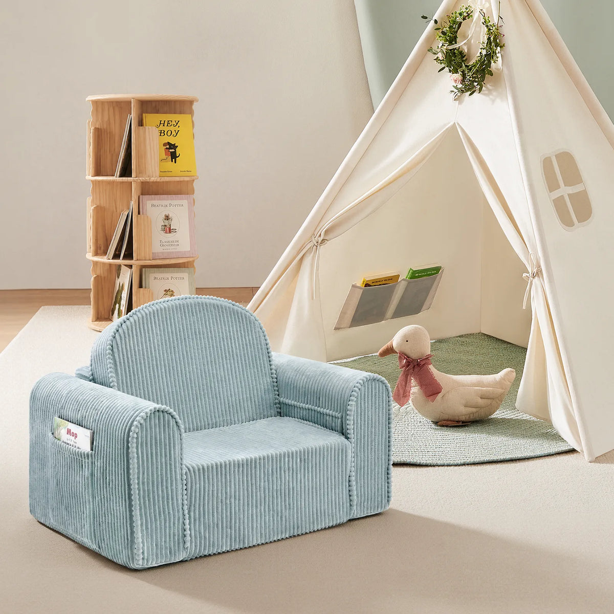 Transform your child’s playroom into an inviting reading nook with the Tiny Land® Ultimate Reading Retreat: Premium Teepee & Corduroy Lounger by Tiny Land INC—a stylish set featuring a soothing light blue corduroy armchair, a charming soft toy duck with a scarf, a compact bookshelf for children’s books, and a white Montessori-inspired teepee adorned with a festive wreath.|Soft Teal