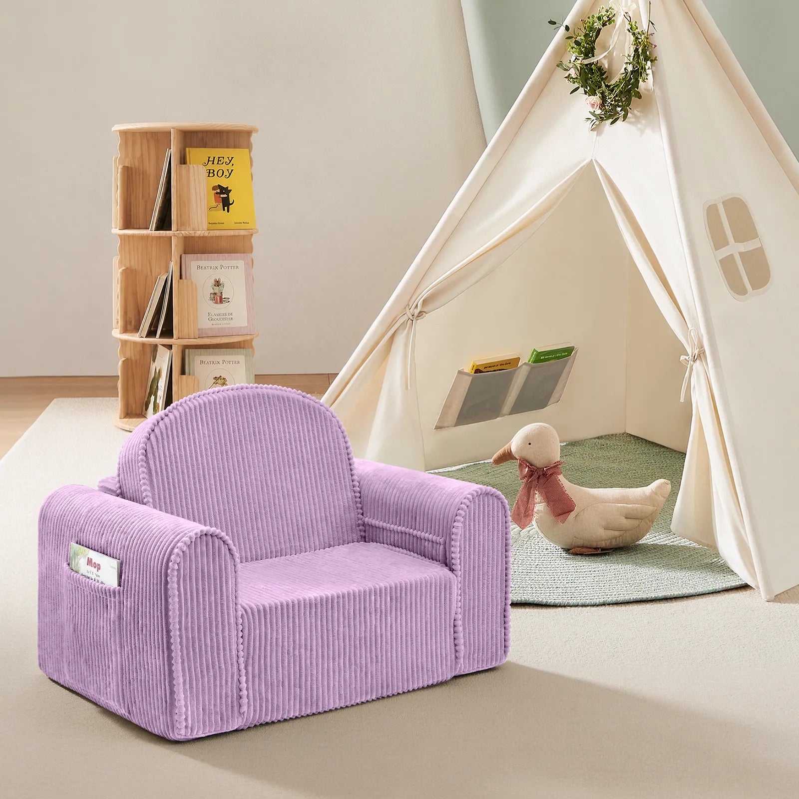 Transform your child’s room into the perfect reading nook with the Tiny Land® Ultimate Reading Retreat: Premium Teepee & Corduroy Lounger by Tiny Land INC. This cozy space features a purple corduroy armchair, a wooden bookshelf filled with books, and a cream Montessori-inspired teepee tent with handy pockets. The look is finished off with a plush duck toy wearing a scarf, creating an inviting and imaginative haven for little readers.|Purple