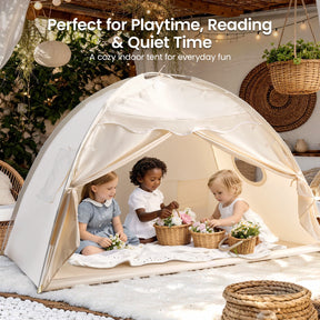 Three young children relax in a cozy Tiny Land® Kids Bed Tent by Tiny Land, surrounded by flowers, wicker decor, and plants. Natural light fills this warm indoor hideaway. Text promotes this delightful tent for kids' bedrooms or playrooms.|Beige