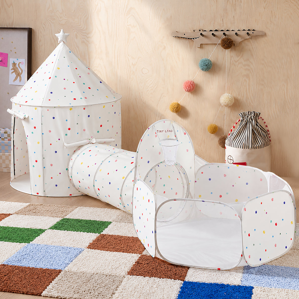 A white Tiny Land® Compact Adventure 3-in-1 Play Tunnel with a cone-top tent, connecting tunnel, and mesh-walled ball pit featuring a small basketball hoop.|Colorful Dots