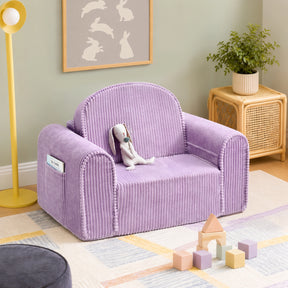 A Tiny Land® GentleSnug Corduroy Kid Chair in soft lavender, perfect as a kids’ lounger or toddler chair, with a stuffed bunny sits on a pastel rug in a cozy room. Wooden blocks, a plant on a wicker table, and bunny art add charming touches to the space.|Purple