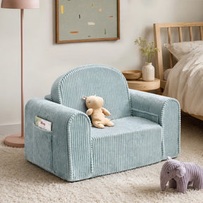 A Tiny Land® GentleSnug Corduroy Kid Chair in light blue sits on a beige rug in a child’s room, with a plush bear placed on the seat and a stuffed elephant on the floor. In the background, there is a framed abstract artwork and a pink lamp.|Soft Teal