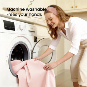 A smiling woman loads a light pink Tiny Land® Kids Bed Tent into a washing machine. "Machine washable. Frees your hands." appears on the image, set in a bright, modern laundry room. Brand: Tiny Land.|Pink