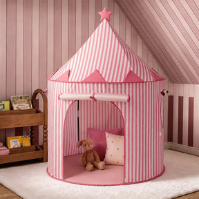 A Tiny Land® Kids Tent – Indoor Tent for Toddlers in pink and white stripes, topped with a star, stands in a pink room. Inside the tent are a brown stuffed bunny and a pink pillow decorated with stars. A wooden shelf holding books is placed nearby.|Pink